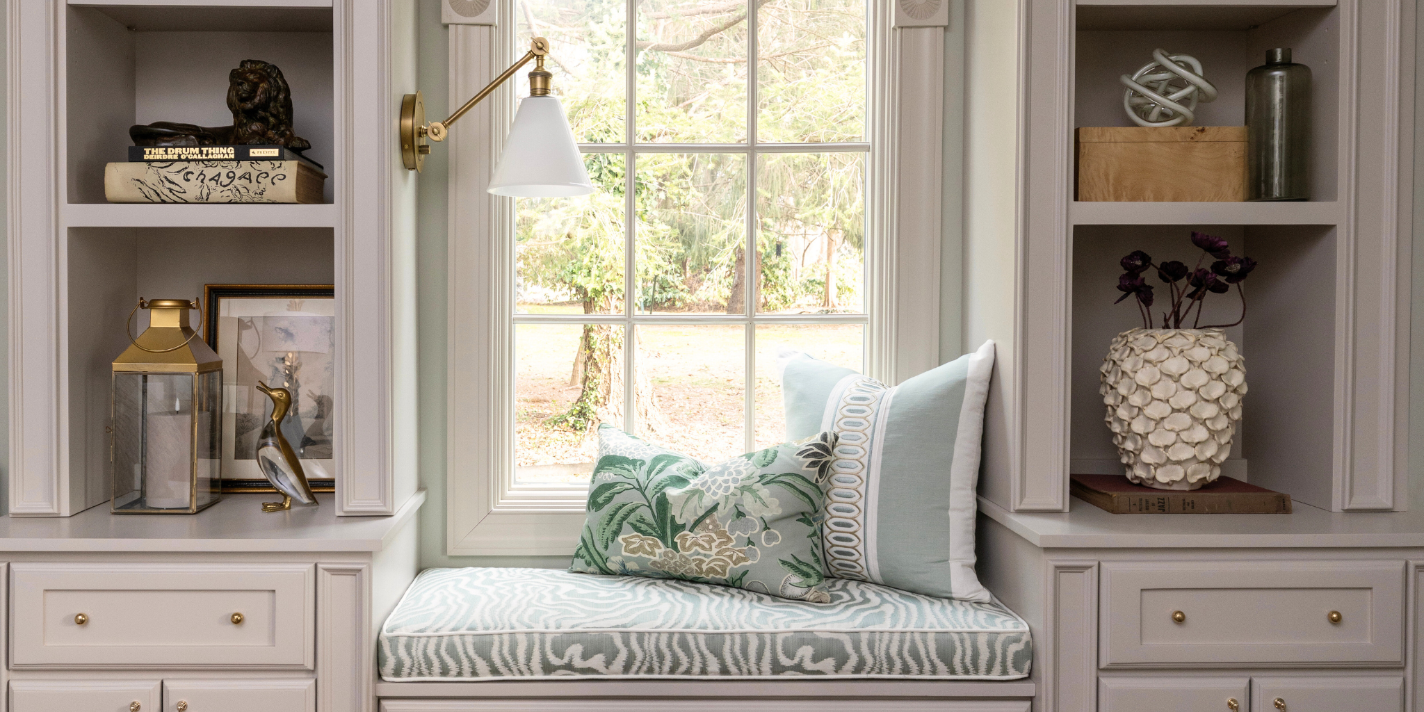 Decorative interior with a bench, pillows, and shelves in Huntington, NY